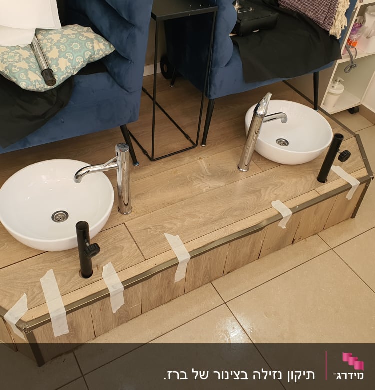 שני כיורים עם ברזים מותקנים על משטח עץ